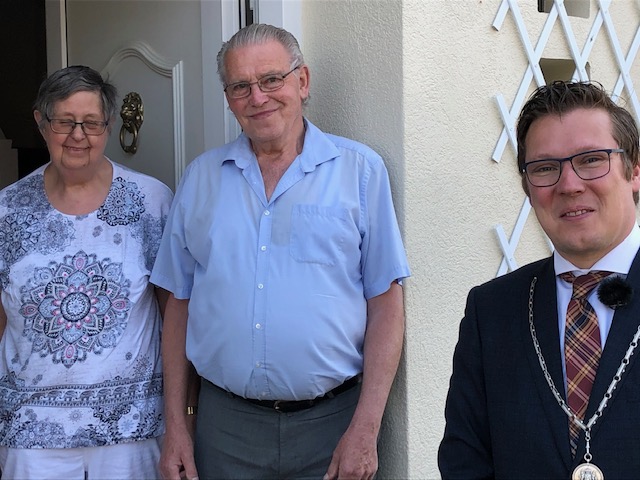 De heer Herman Geerlings met zijn vrouw en burgemeester Vostermans bij de voordeur.