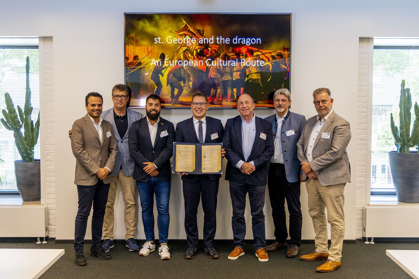 João Oliveira (wethouder Monção), Maties Marti (voorzitter Medieval Association of Saint George's Legend Montblanc), Oriol Palisso (burgemeester Montblanc), Bob Vostermans (burgemeester gemeente Beesel), Pascal Goergen (wethouder Grez-Doiceau), Sandro Bauer (burgemeester Furth im Wald) en Hans van Kruchten (voorzitter Stichting Draaksteken Beesel) met de ondertekende intentieovereenkomst.