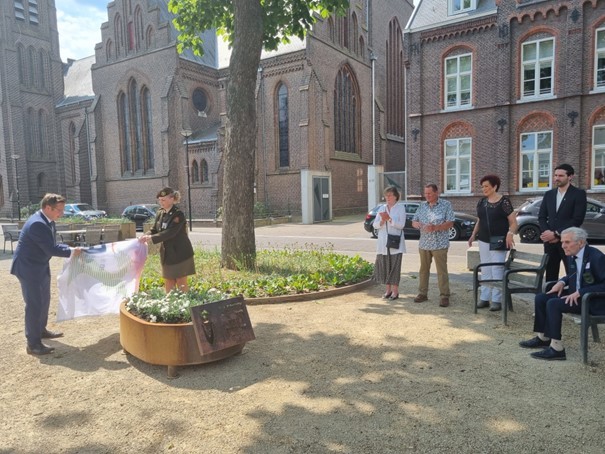 Burgemeester Bob Vostermans onthult onder toeziend oog van een aantal veteranen het witte anjer perkje in de vorm van een cortenstalen bloembak. 