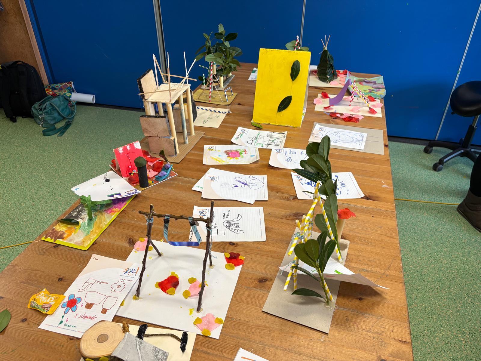 Geknutselde ontwerpen van kinderen voor het plein in Bösdael