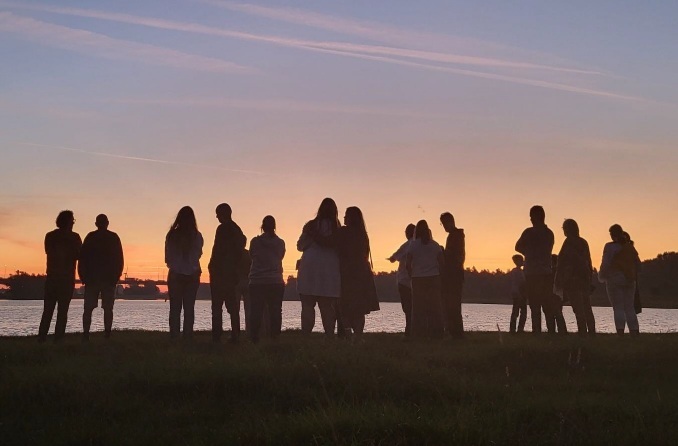 SIlhouetten van mensen die buiten wandelen tijdens zonsopkomst
