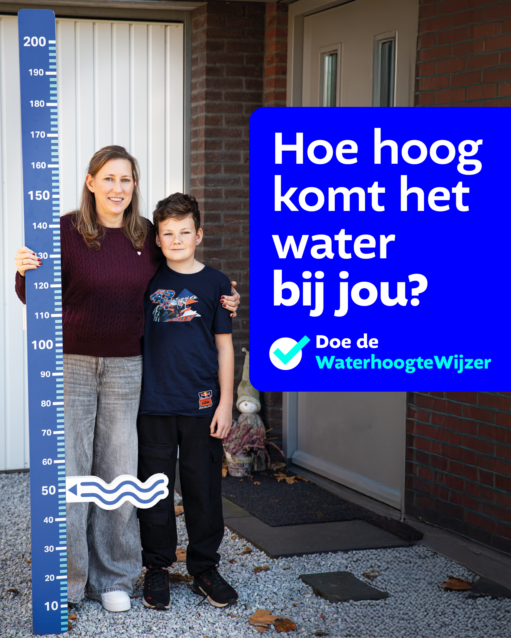Moeder en kind met een waterhoogte meetlat voor hun huis