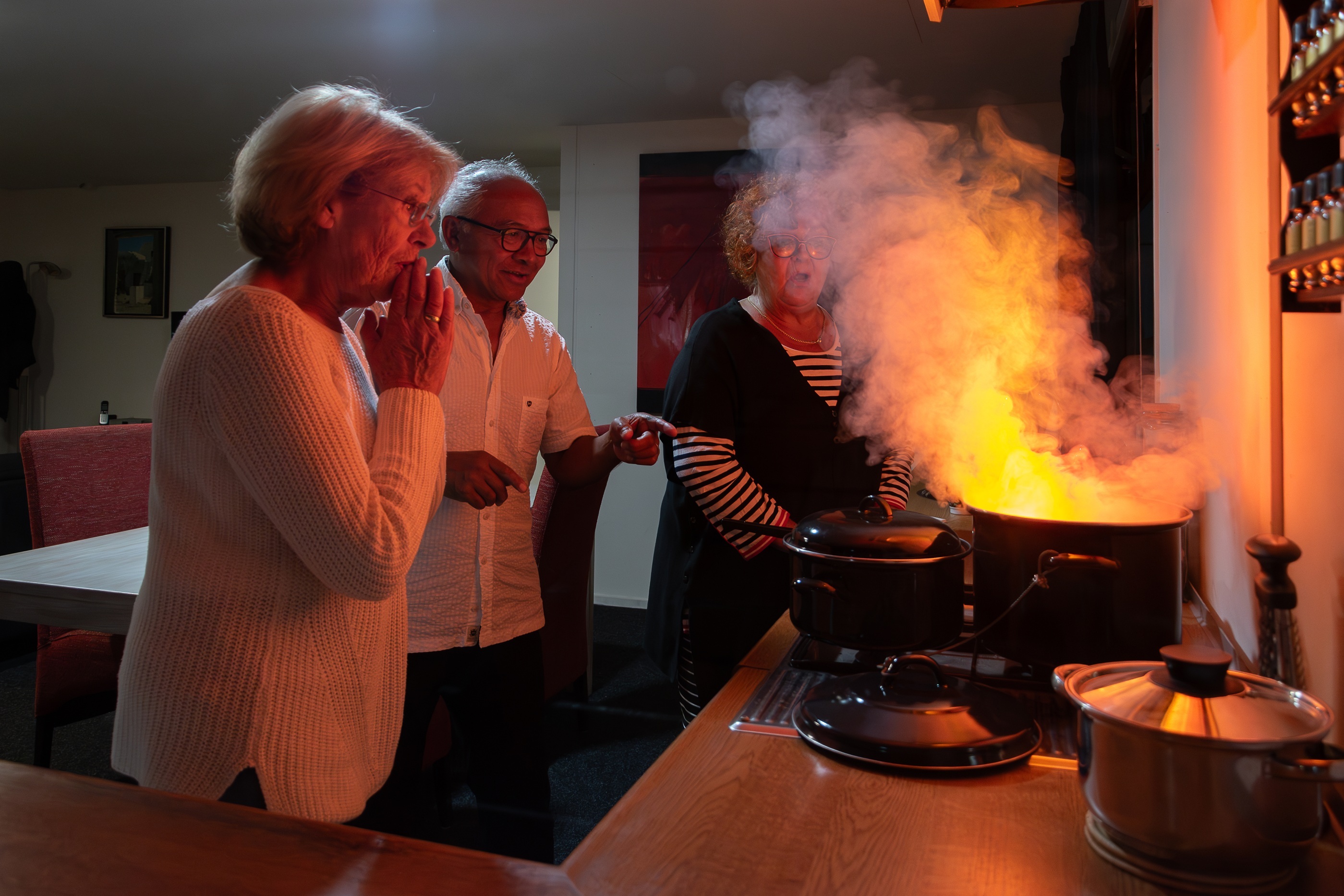 Ouderen bij brandende pan in keuken