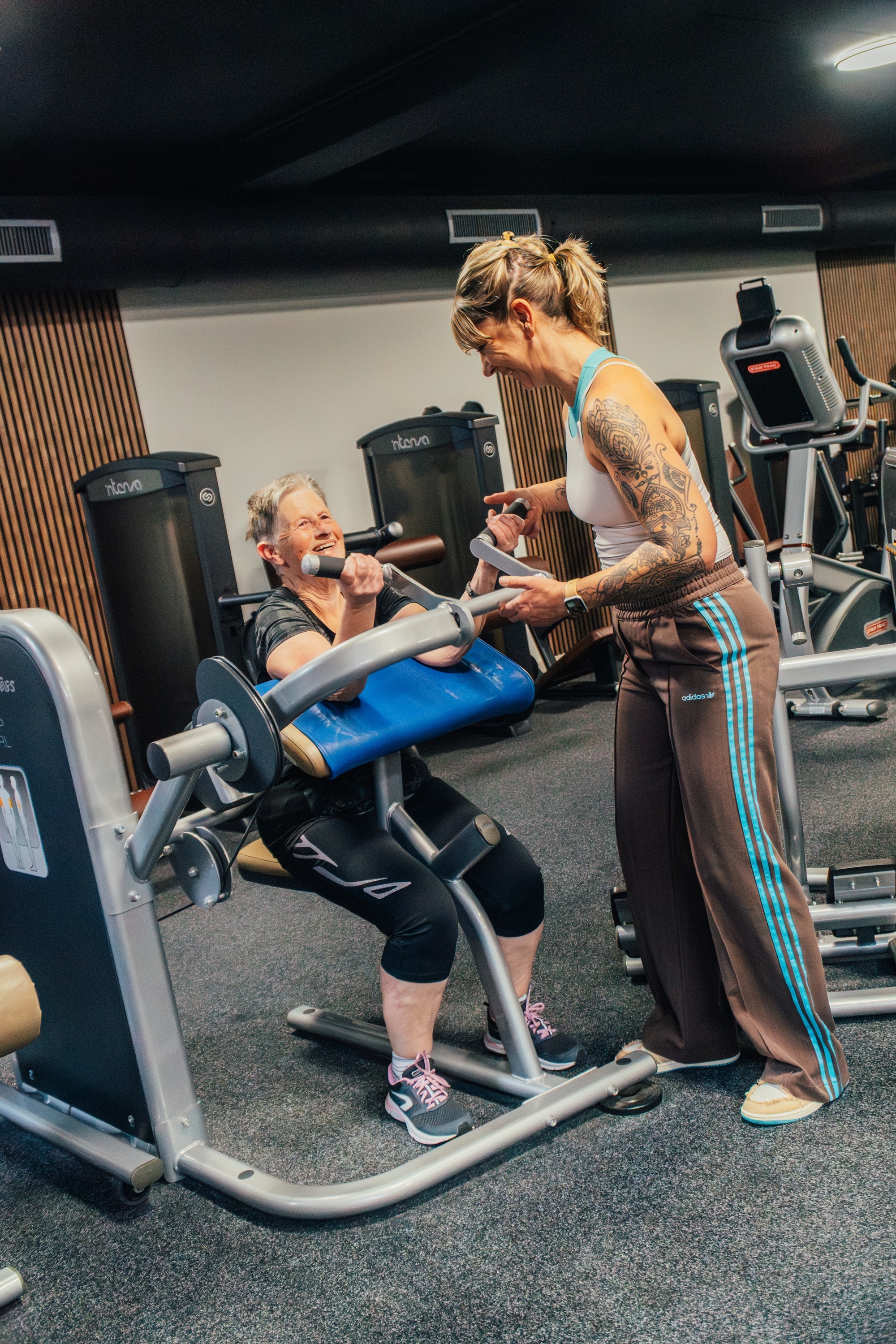Sporter met begeleider op een apparaat bij Active Premium Health Club
